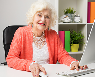 senior woman at computer, dissolving the myths of aging
