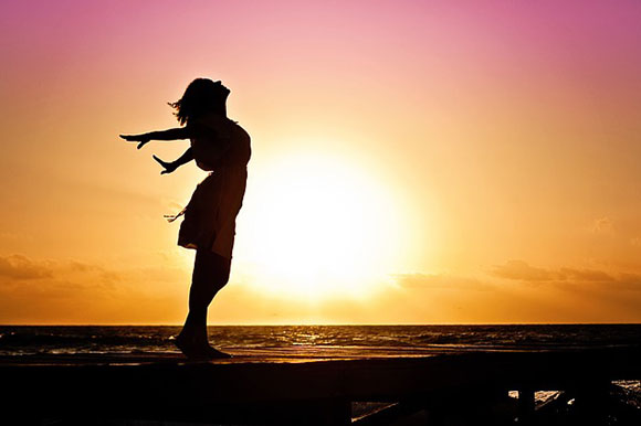 silhouette of woman against sun in sky, happy, free
