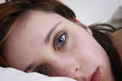 close-up of woman lying awake, worrying, eft for thoughts that prevent sleep
